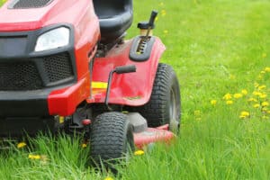 Closeup of red tractor mowing grass